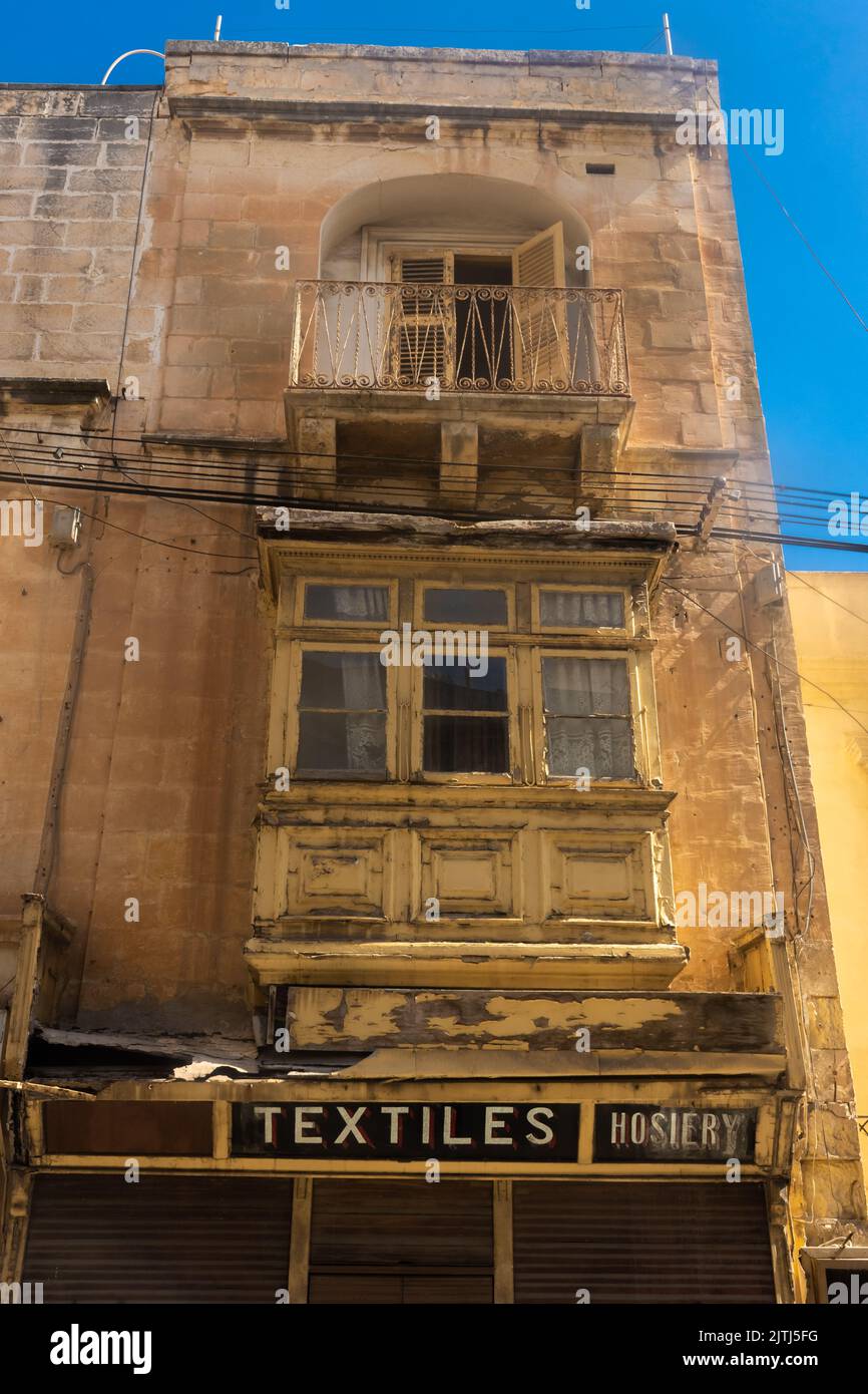 Sehr altes Gebäude mit einem alten Textilgeschäft in der Altstadt von Gzira, Malta Stockfoto