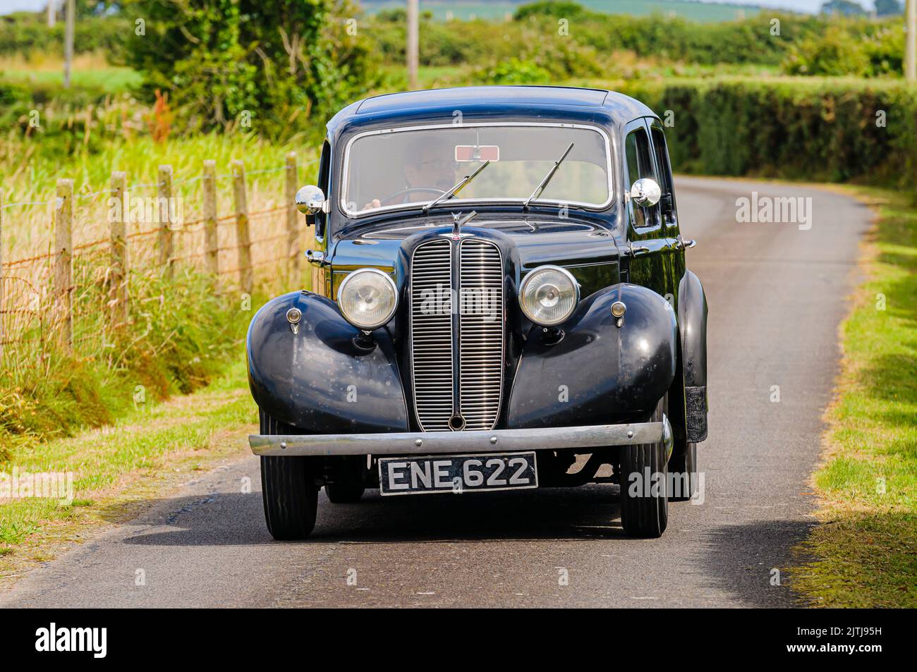 1938 Hillman Minx fährt eine sehr enge Landstraße entlang. Stockfoto