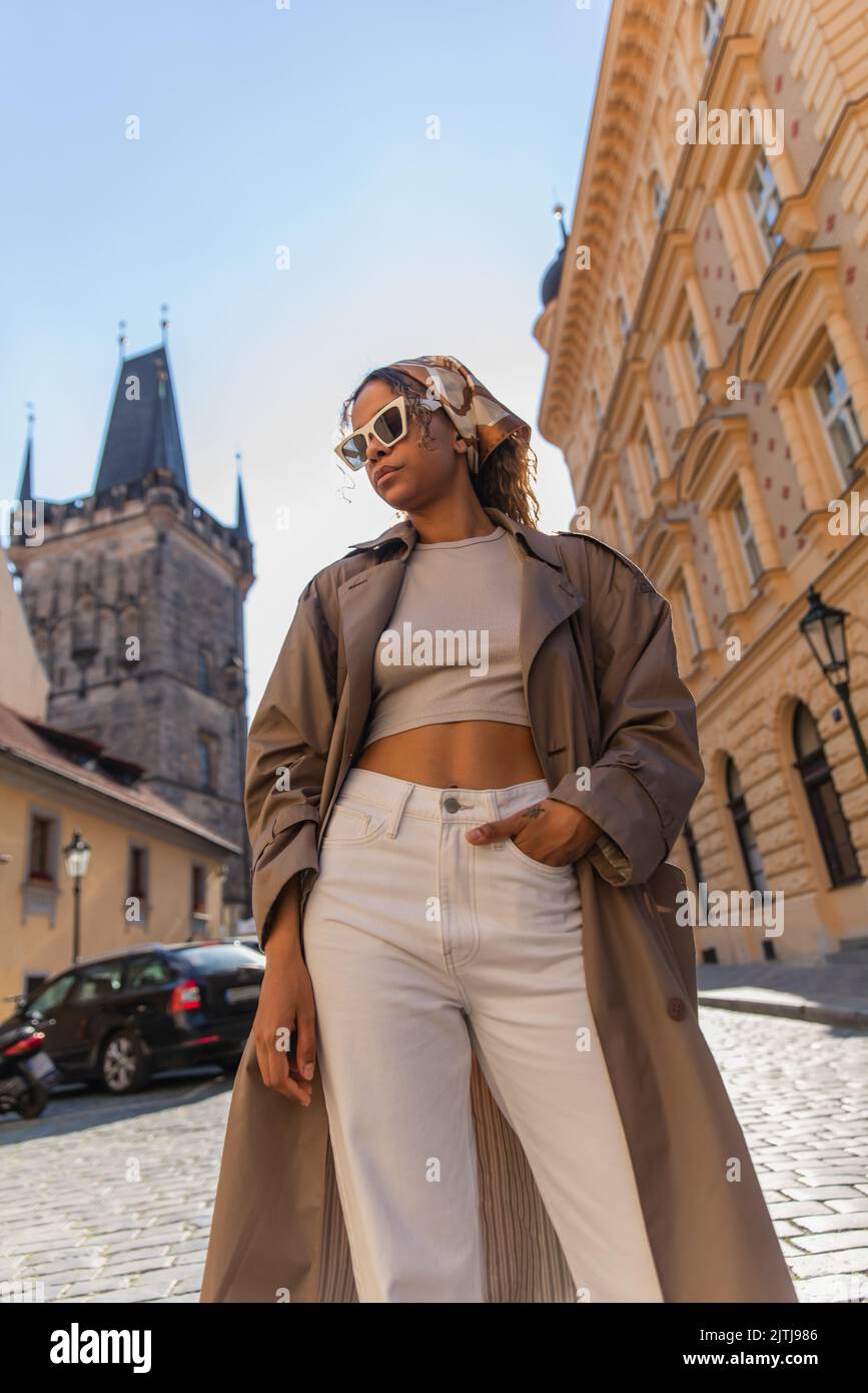 Low-Angle-Ansicht der afroamerikanischen Frau posiert in der Nähe des alten Rathausturms in prag Stockfoto
