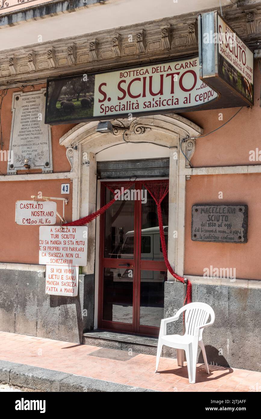 Eine Metzgerei in einem sizilianischen Dorf - eines der Schilder in sizilianischem Dialekt lautet: „Wenn Sie lange und gesund leben möchten, essen Sie von Hand hergestellte Wurst“ Stockfoto
