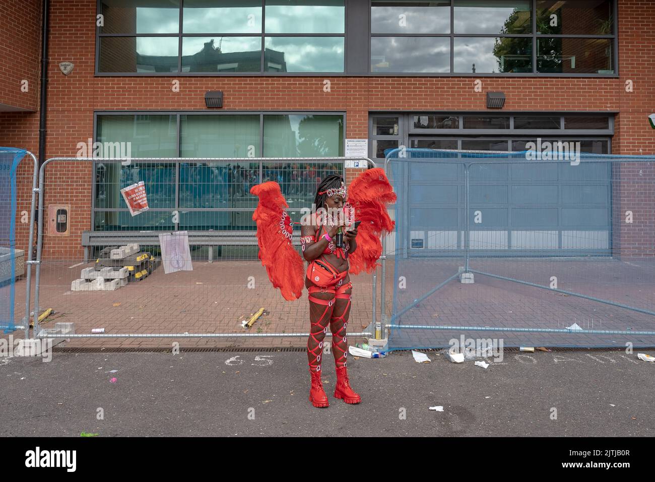 Während des Notting Hill Carnival 2022 im Westen Londons macht eine lebhafte Samba-Tänzerin eine Pause Stockfoto