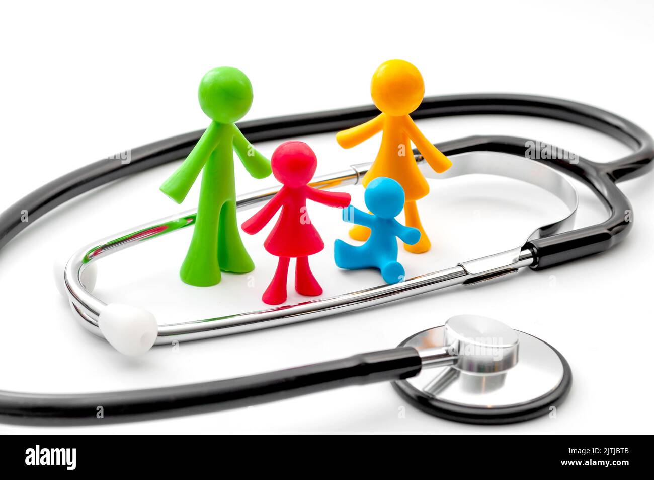 Stethoskop- und Miniaturfiguren, die Eltern und Kinder in einem traditionellen Haushaltskonzept für die Krankenversicherung Familienplan, Gesundheit darstellen Stockfoto