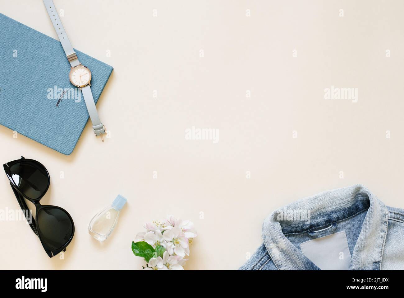 Ein Blog-Konzept zu schreiben. Notizblock, Damenzubehör, Kleidung, Armbanduhren, Sonnenbrillen, Blumen auf beigefarbenem Hintergrund. Mode und Schönheit flach legen. Stockfoto