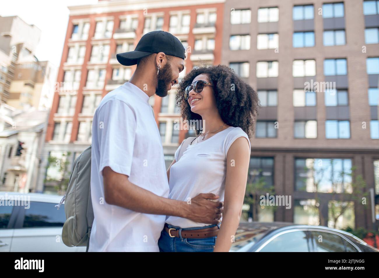 Ein Mann umarmt eine junge Frau und schaut verliebt Stockfoto