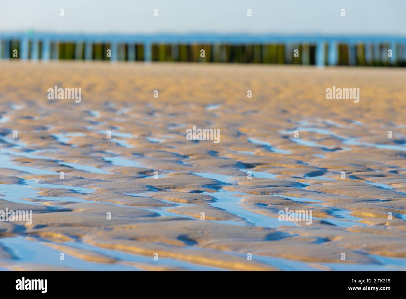 Typischer Blick auf die Küste nach der Flut, mit dem salzigen Wasser, das erstaunliche Muster am Strand hinterlässt, während das Wasser einen Weg zurück findet Stockfoto