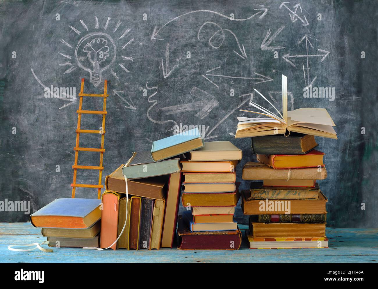 Bildung gibt Orientierung, Bücher, Tafel und Leiter des Erfolgs.Lernen, Wissen, Humanismus, zurück zur Schule Konzept Stockfoto