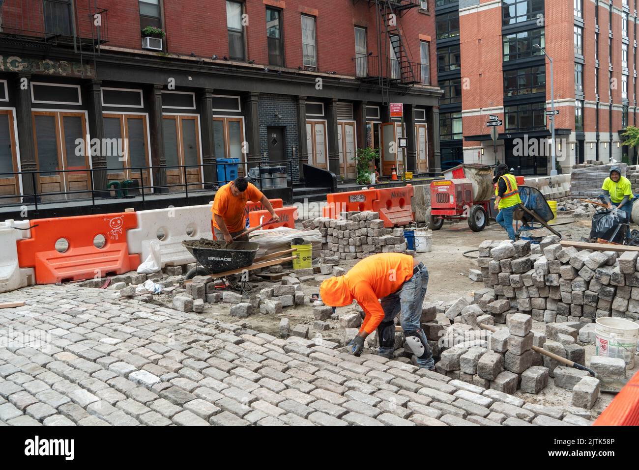 Arbeiter, die die Kopfsteinpflaster auf der Desbrosses Street in Tribeca, Manhattan, vor einem Eingang zu einem Luxushotel, das im September 2022 eröffnet wird, auslagern. Stockfoto