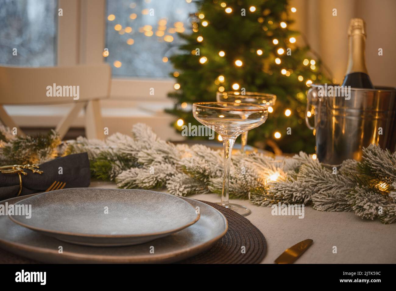 Weihnachtliche festliche Tischdekoration, Goldschmuck und Champagner. Abendessen mit der Familie oder Silvesterparty. Stockfoto
