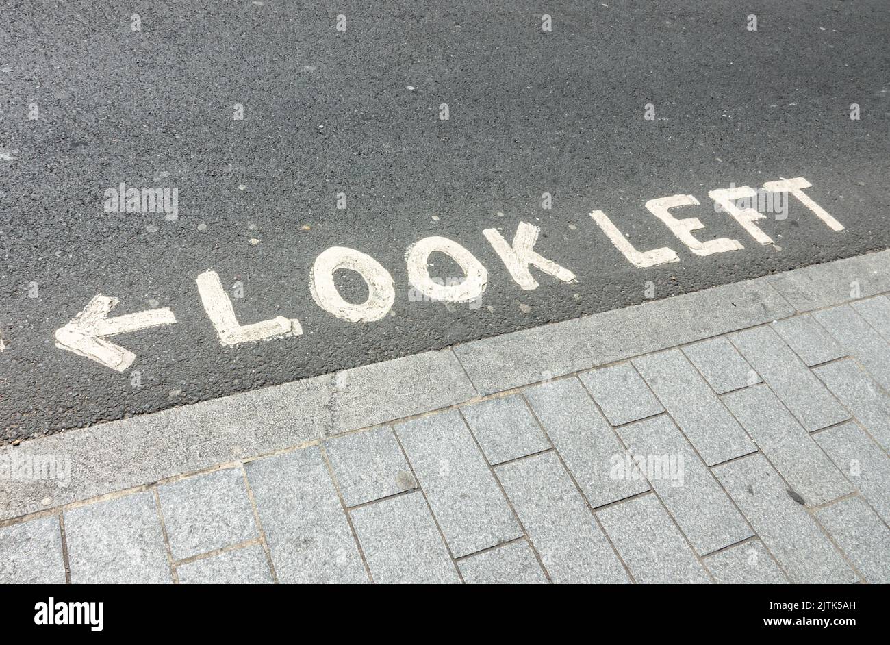 Blick nach links, geschrieben an einer Fußgängerüberführung in London, Großbritannien Stockfoto