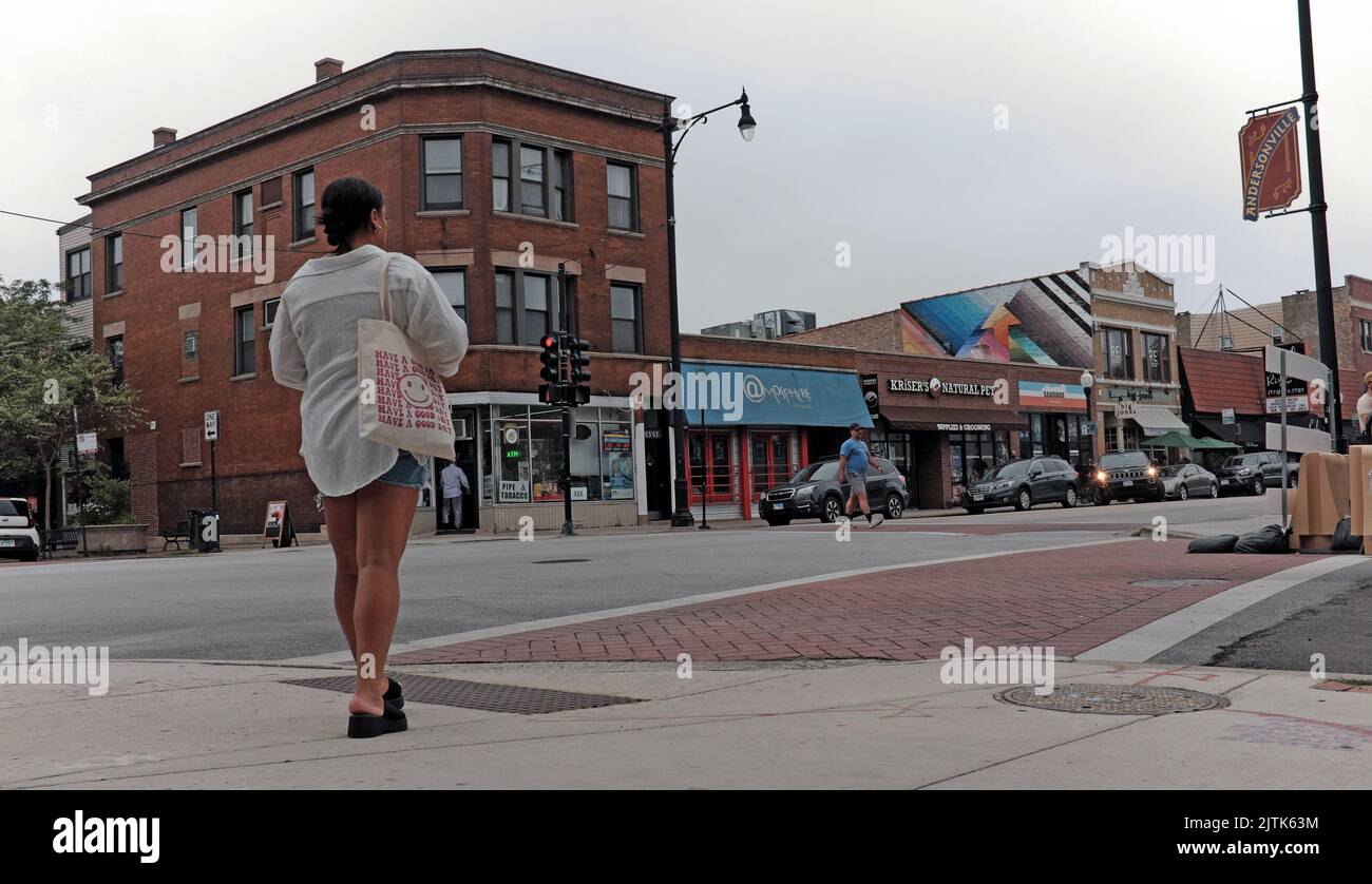 Eine Frau überquert im Sommer die Straße im Stadtteil Andersonville in Chicago, Illinois, USA. Stockfoto