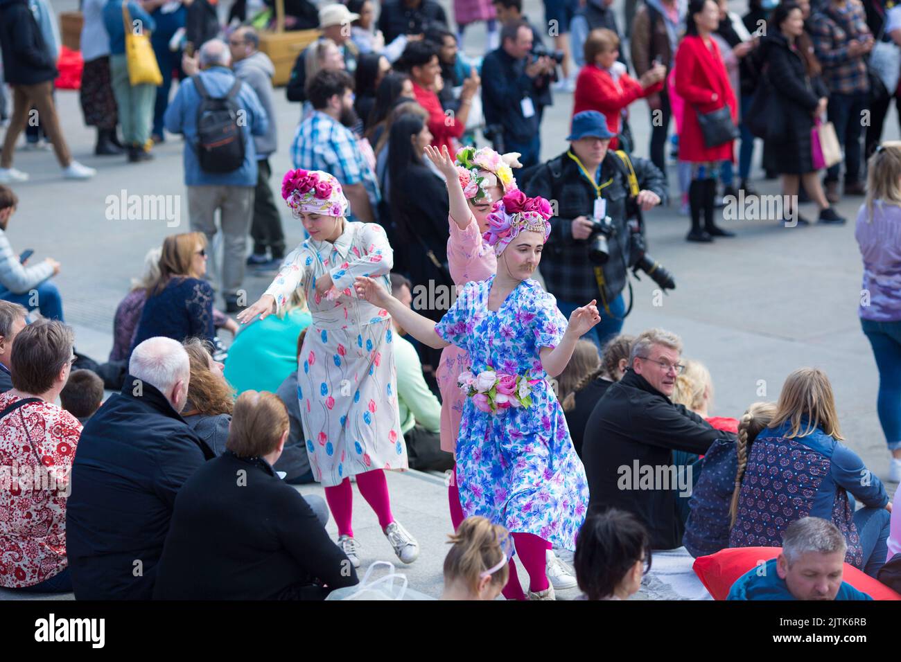 Die Menschen sehen sich Tanzaufführungen an, während sie sich zu den St. George’s Day Feiern auf dem Trafalgar Square im Zentrum von London versammeln. Stockfoto