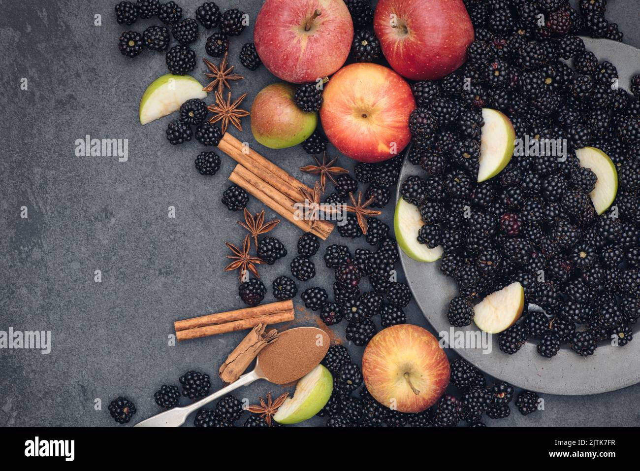 Geernte Brombeeren und Äpfel mit Zimt und Sternanisgestein auf Schiefer Stockfoto