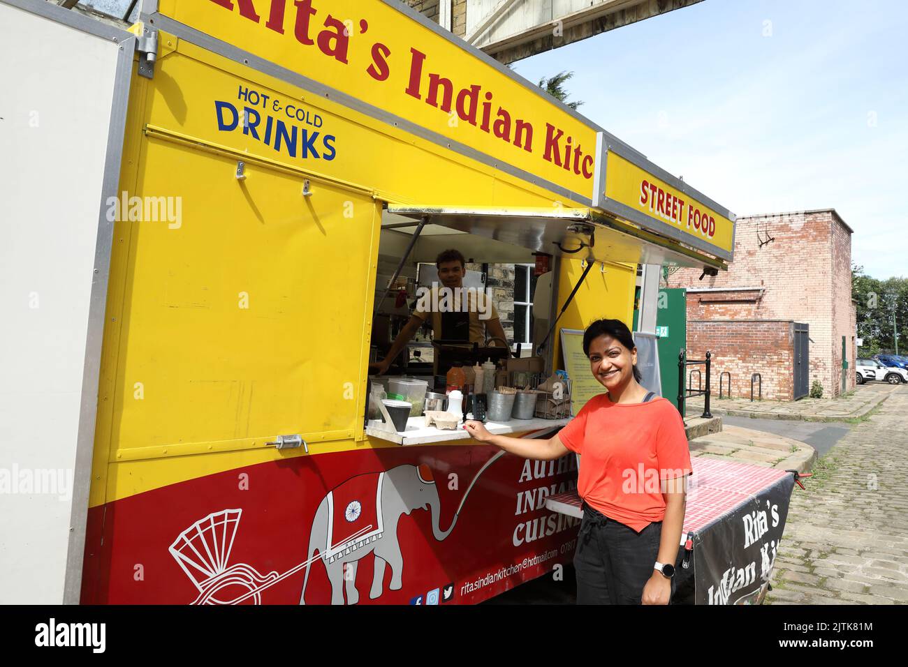 Rita in Rita's Indian Kitchen, einer mobilen Küche, die großartiges authentisches indisches Street Food serviert, serviert im Bradford Industrial Museum, West Yorkshire Stockfoto