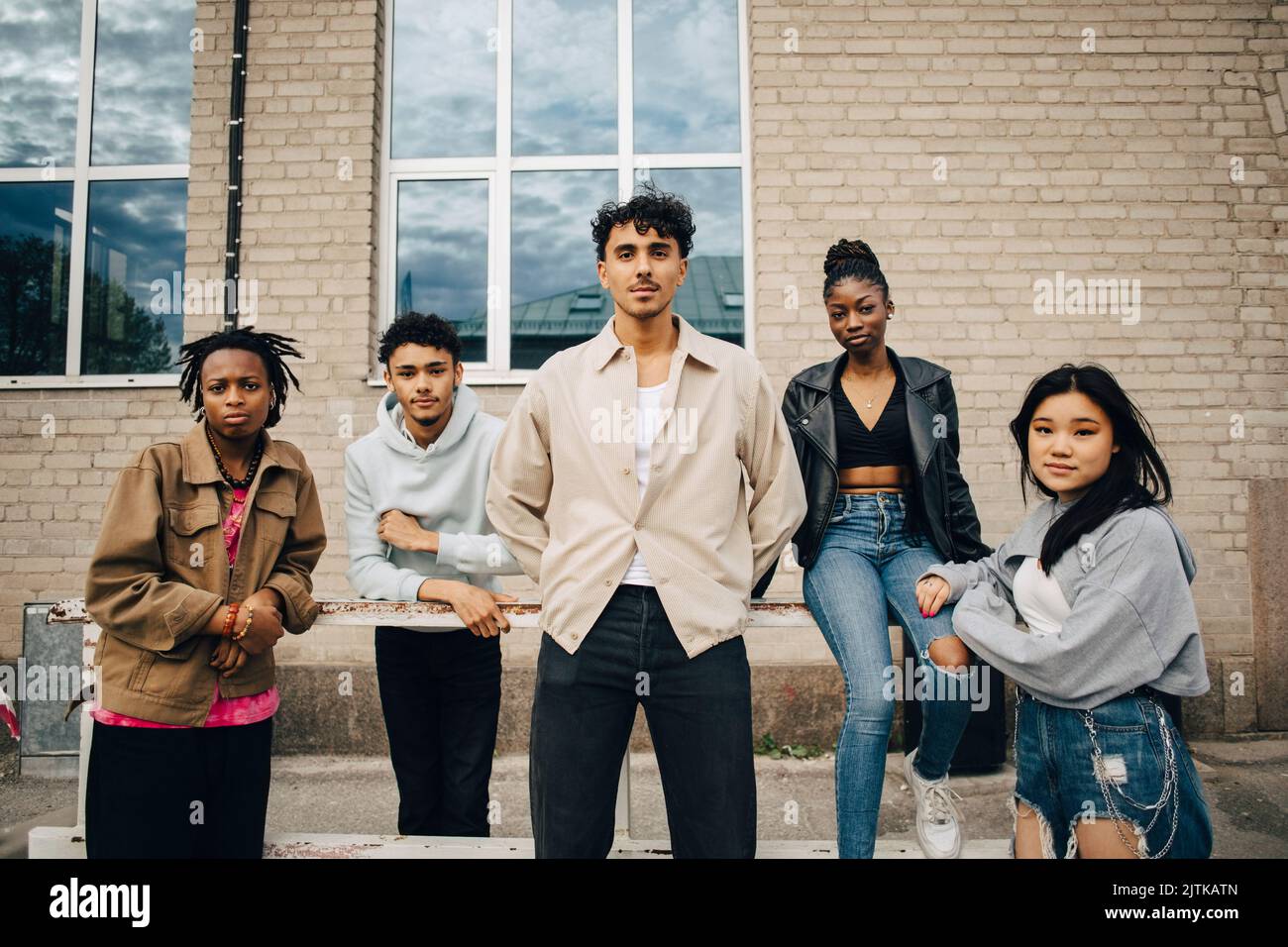 Porträt selbstbewusster multirassischer junger Freunde vor der Wand Stockfoto