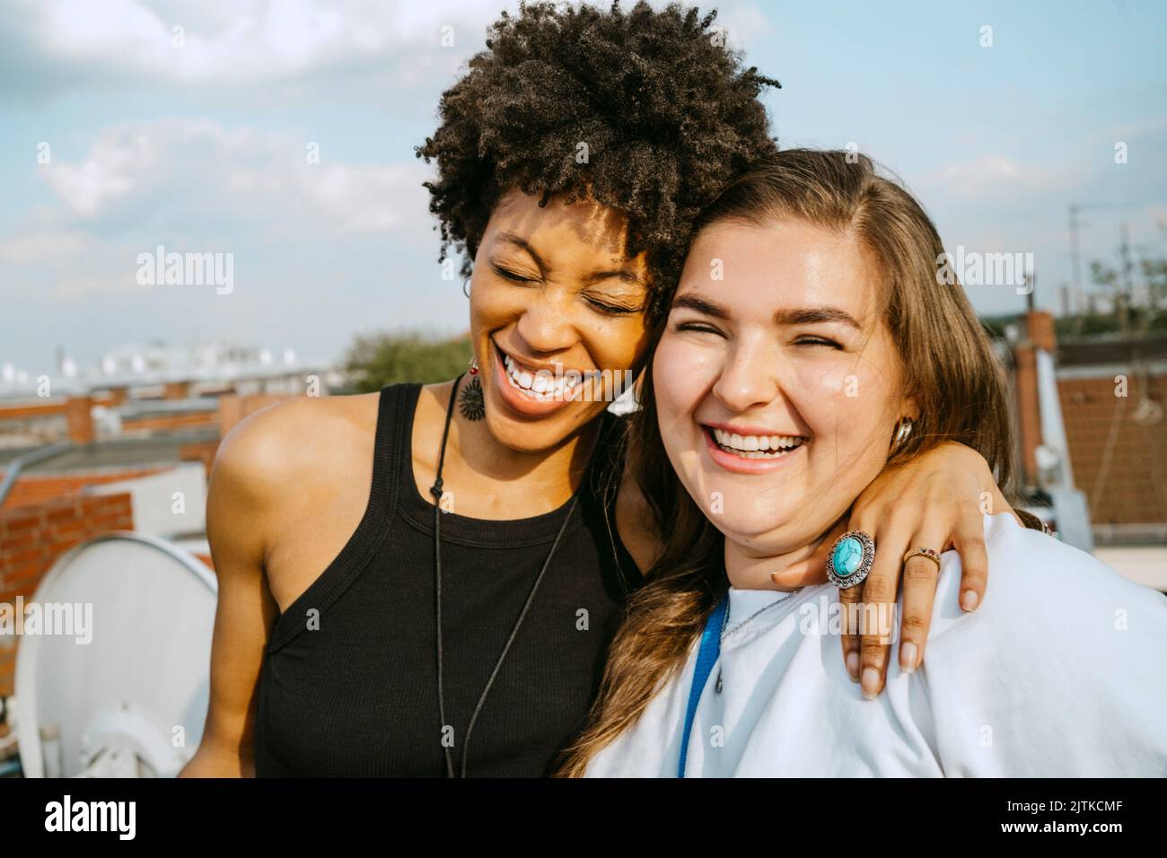 Fröhliche multirassische junge Freundinnen, die an sonnigen Tagen Spaß haben Stockfoto