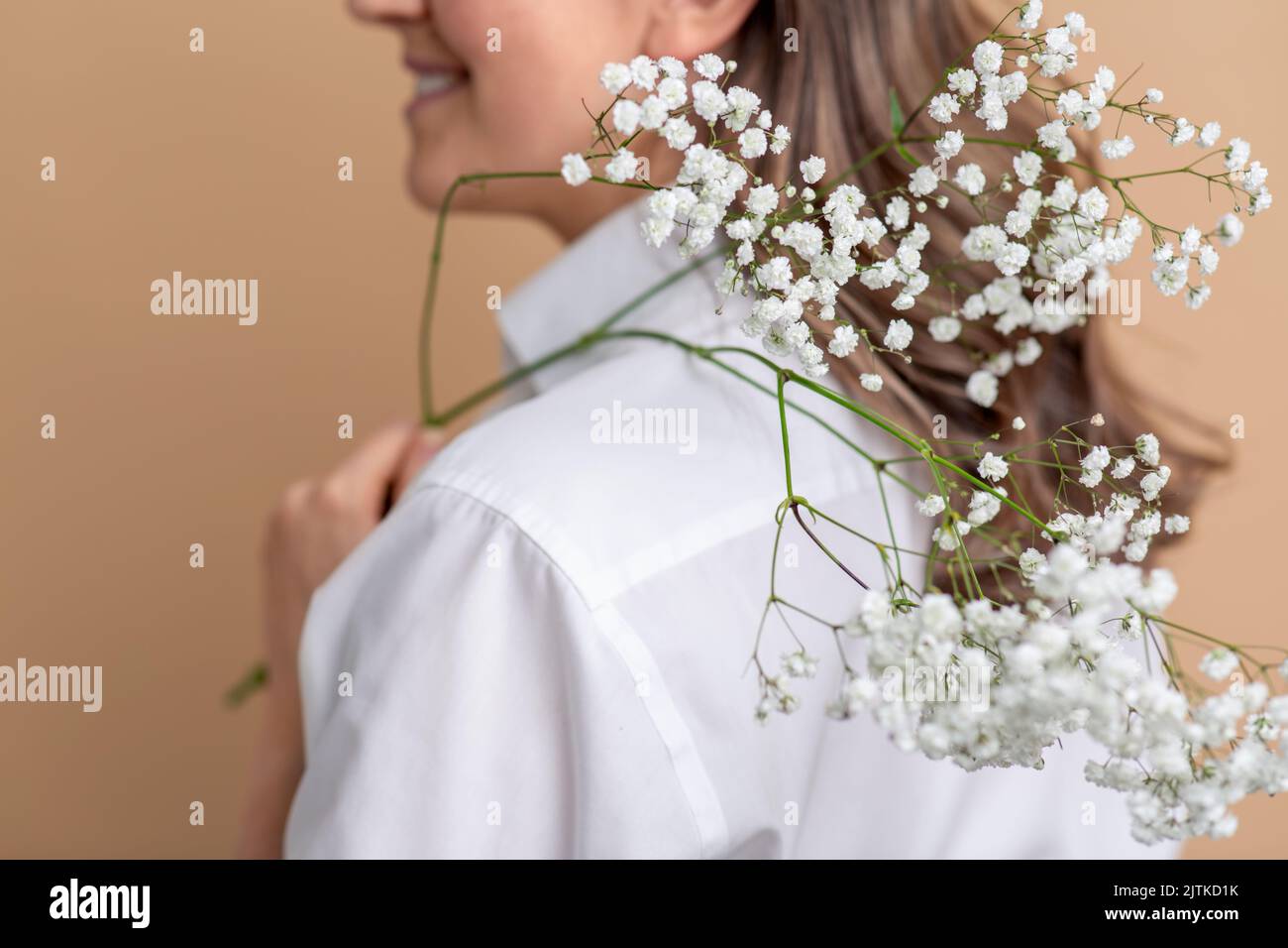 Nahaufnahme einer Frau mit einem Zweig der Gypsophila-Blume Stockfoto