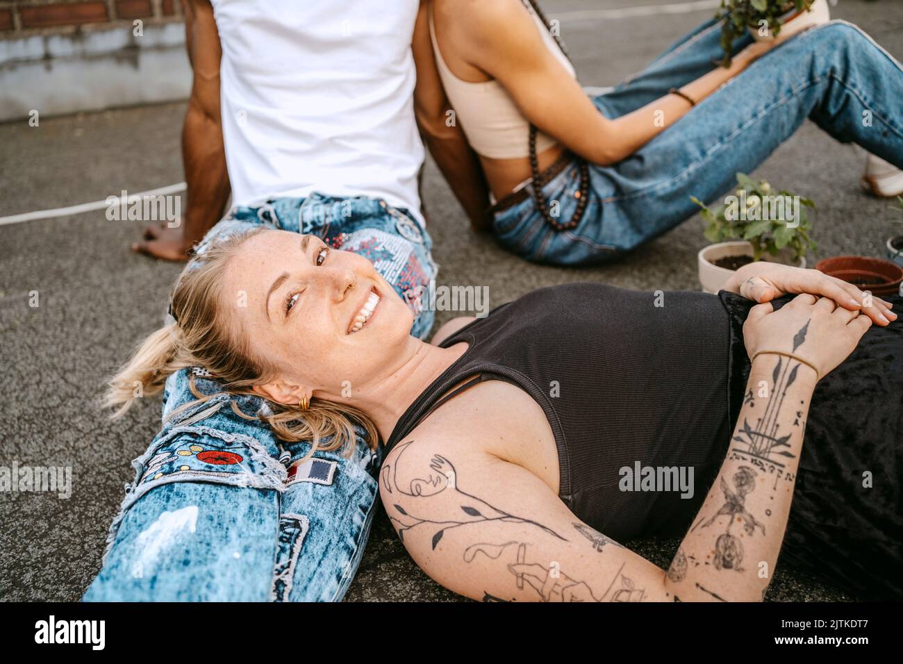 Porträt einer lächelnden jungen Frau, die den Kopf auf dem Schoß des Mannes ruht Stockfoto