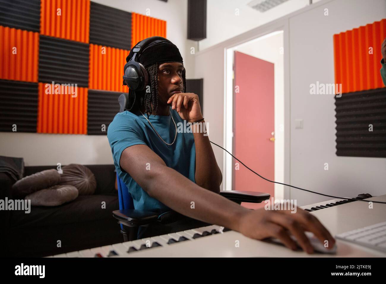 Toningenieur mit Hand am Kinn, der Song im Aufnahmestudio mischt Stockfoto