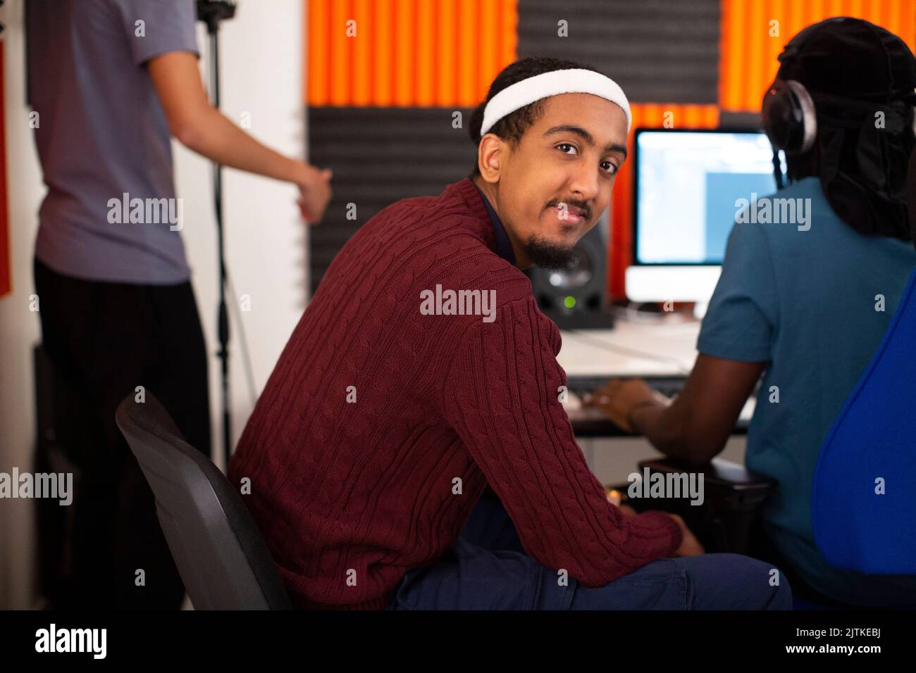 Seitenansicht des Mannes, der im Aufnahmestudio sitzt Stockfoto