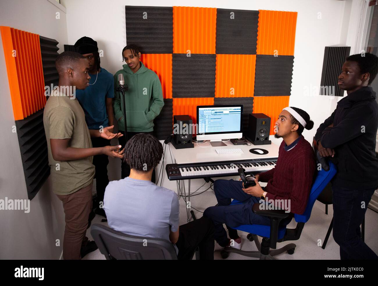 Ein Team von Musikkünstlern diskutiert während sie im Aufnahmestudio sitzen Stockfoto