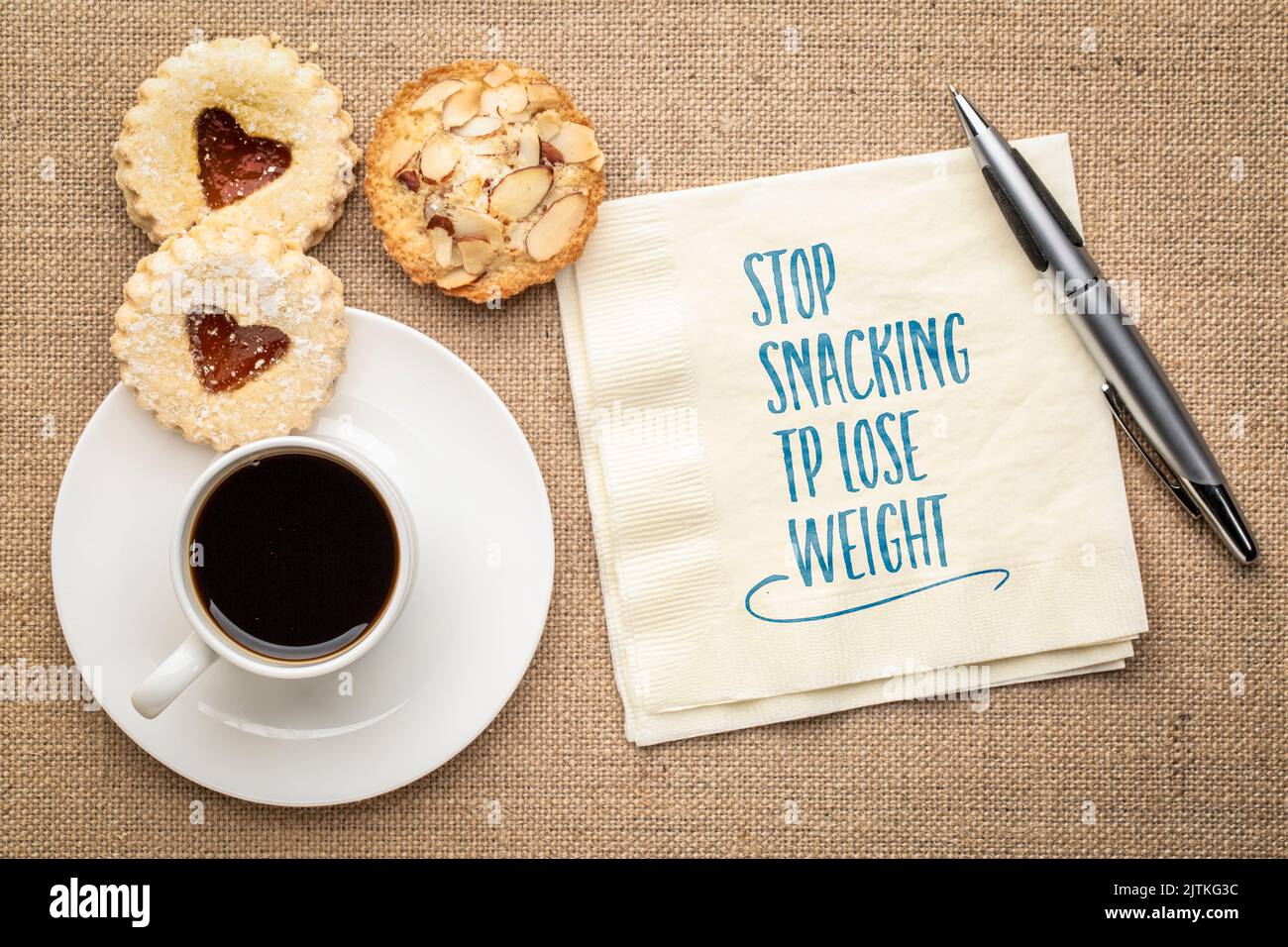 Stoppen Sie Naschen, um Gewicht zu verlieren. Inspirierende Erinnerungsnotiz auf einer Serviette mit Kaffee und Keksen. Gesunde Lebensweise und Ernährung Konzept. Stockfoto