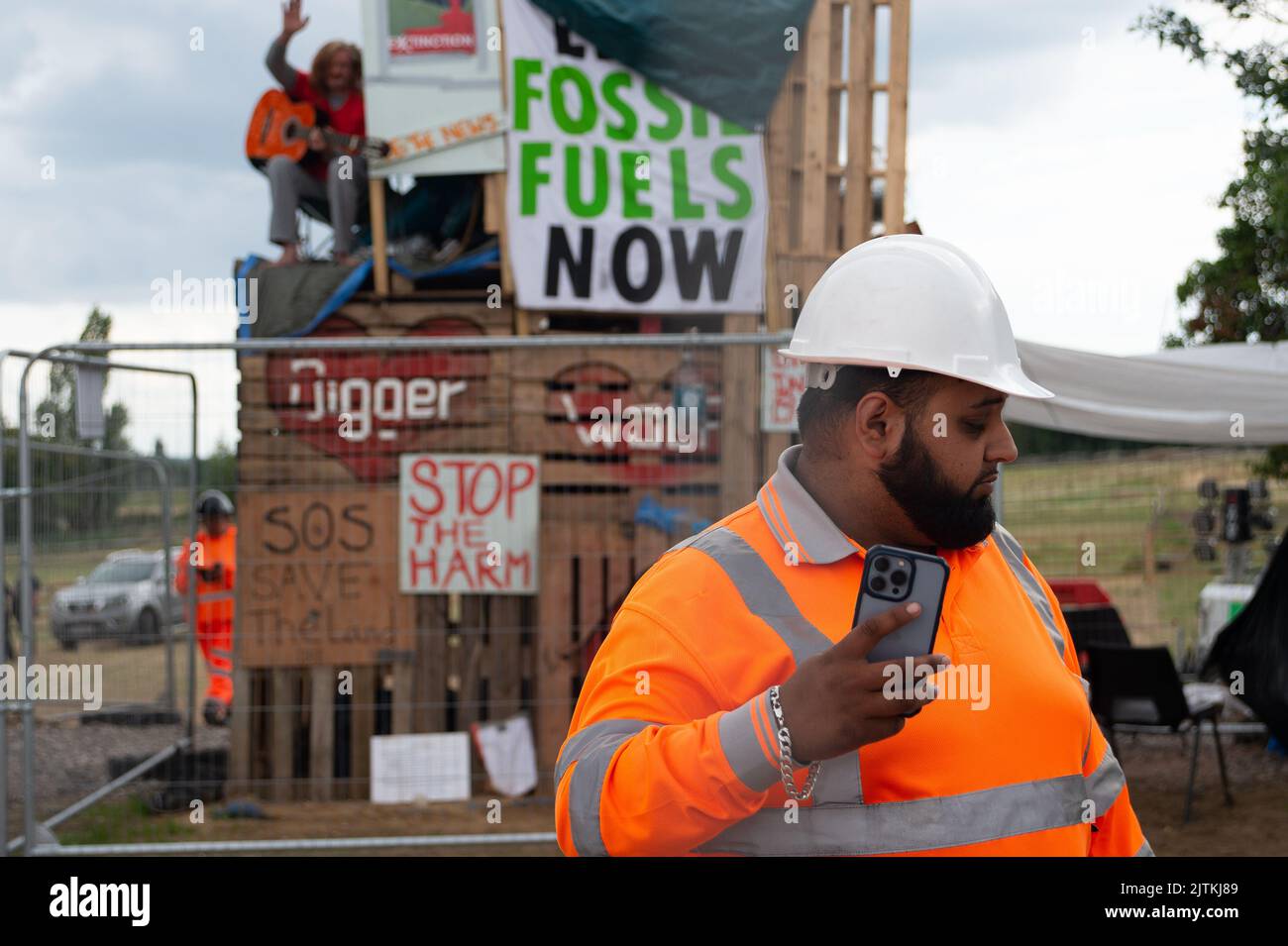 CHERTSEY, Surrey, Großbritannien. 31.. August 2022. Sicherheitskräfte Filmen einen Pressefotografen. Scott Breen, ein erfahrener Klimaaktivist, der als Digger bekannt ist, grub in Chertsey seit 31 Tagen einen Tunnel an Land, wo Esso (ExxonMobil) eine neue Flugzeugbrennstoffleitung nach London Heathrow baut. Folglich wurden alle Arbeiten am Standort eingestellt, und Esso hat eine vorläufige Verfügung über das Gebiet, in dem der Tunnel liegt, erhalten, was bedeutet, dass eine Räumung bevorsteht. Quelle: Maureen McLean/Alamy Live News Stockfoto