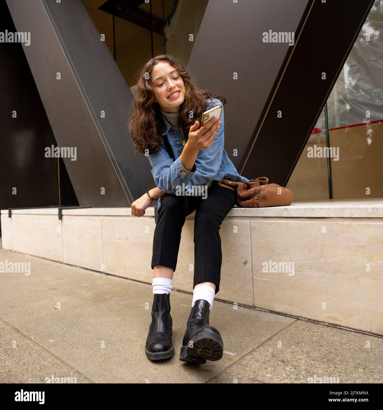 Unbeposed Portrait of Happy Young Woman auf Smartphone Stockfoto