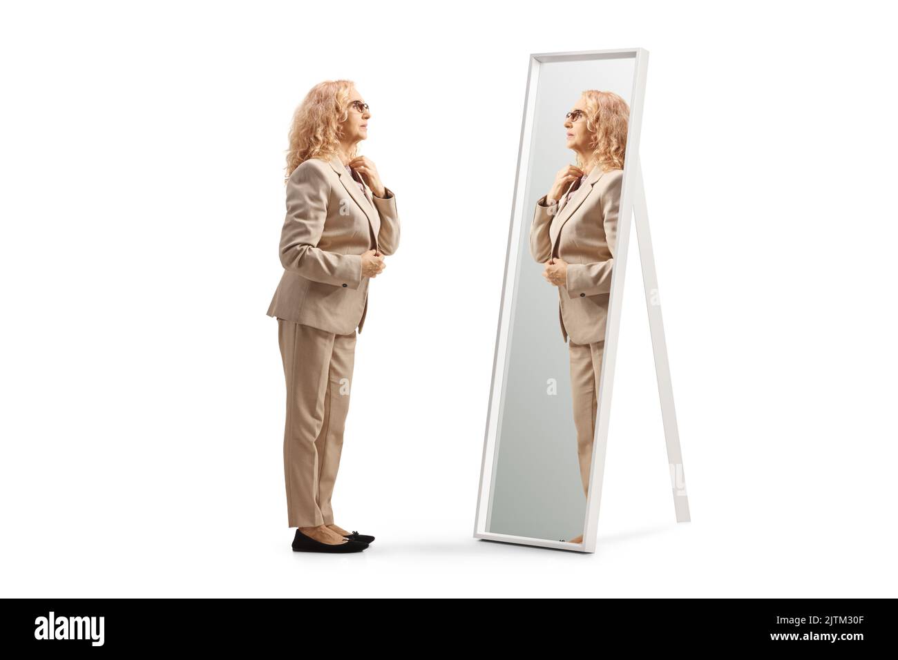 Frau, die sich bereit macht und in den Spiegel schaut, isoliert auf weißem Hintergrund Stockfoto