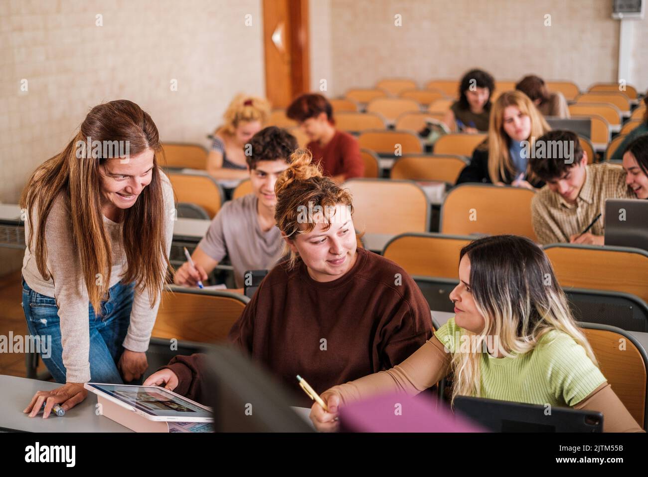 Die Lehrerin löst ihre Zweifel individuell gegenüber ihren Studenten in der Universitätsklasse Stockfoto