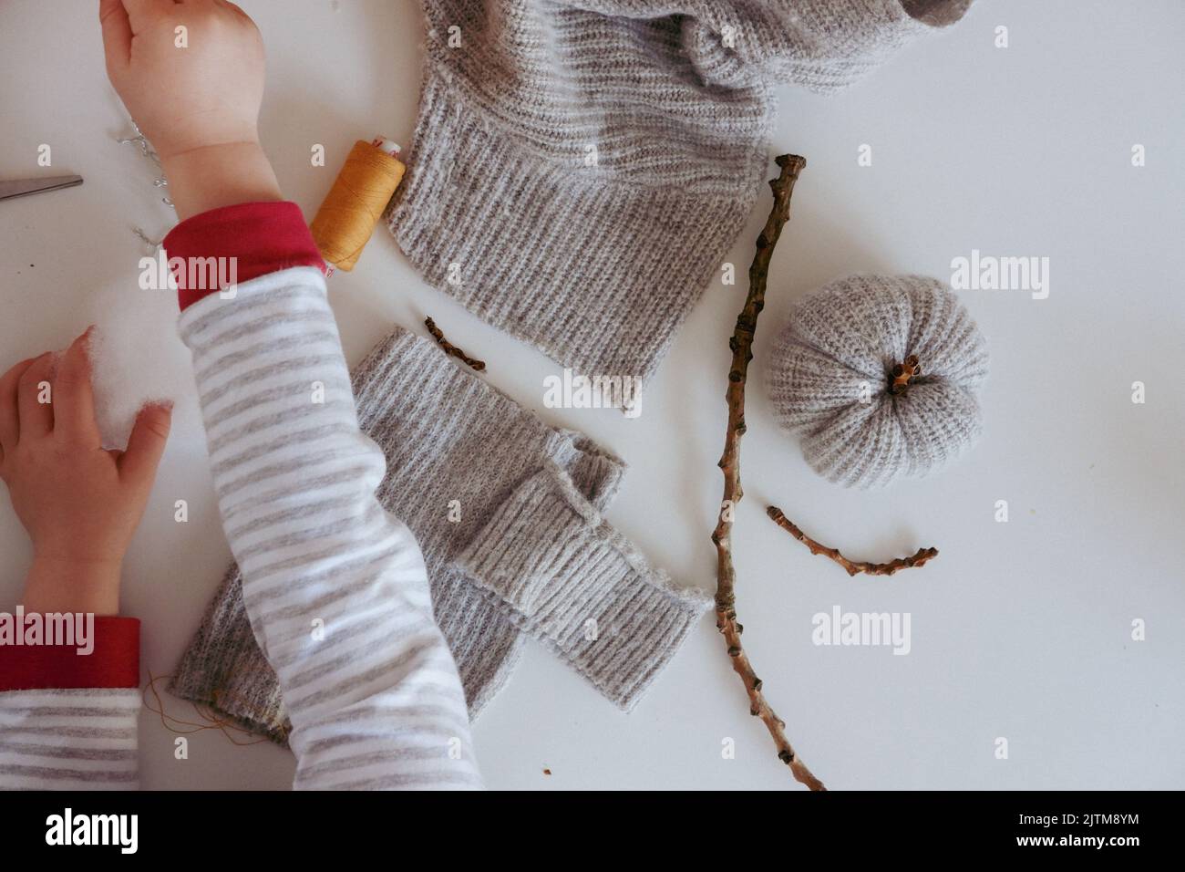 Wie man handgefertigte Kürbisse mit gestrickten Pulloverärmeln macht. Andere Bilder in diesem Set enthalten alle Schritte. Schritte sind unter „zusätzliche Informationen“ verfügbar. Stockfoto