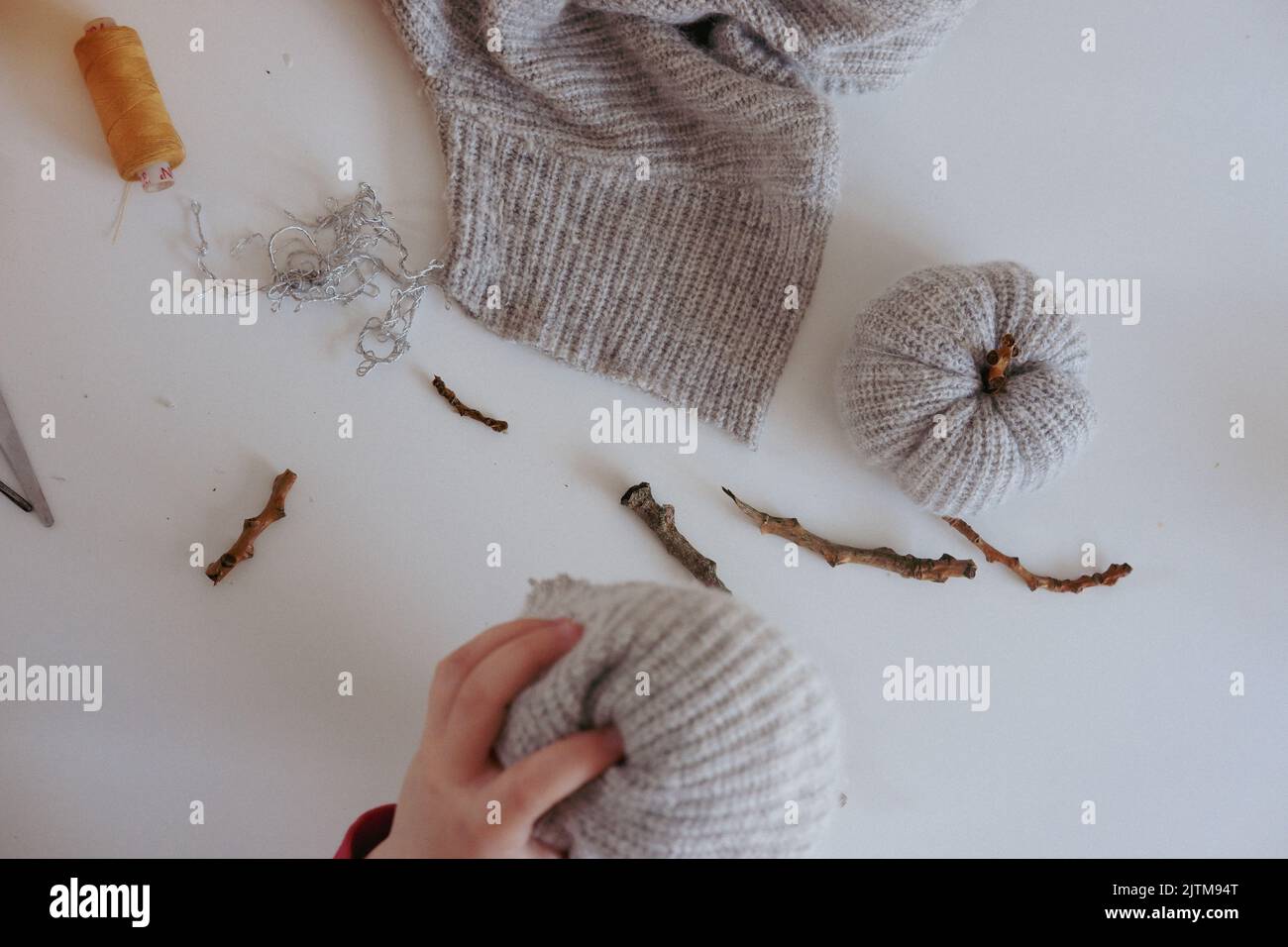 Wie man handgefertigte Kürbisse mit gestrickten Pulloverärmeln macht. Andere Bilder in diesem Set enthalten alle Schritte. Schritte sind unter „zusätzliche Informationen“ verfügbar. Stockfoto
