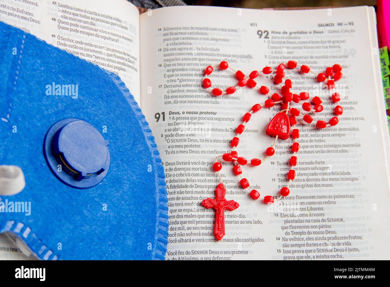 bibel mit blauer Maske und rotem Rosar viel Glauben und Schutz vor dem Corona-Virus in Brasilien Stockfoto