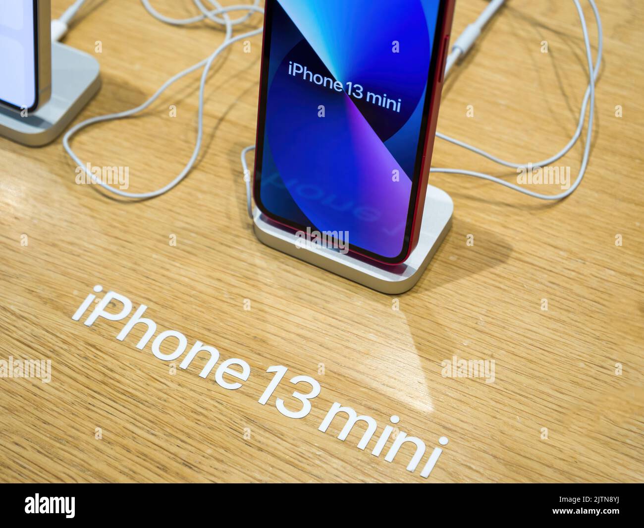 Paris, Frankreich - 3. Nov 2021: Nahaufnahme des neuen iPhone Smartphones 13 mini von Apple Computers mit Aufschrift auf dem Holztisch im Apple Store Stockfoto