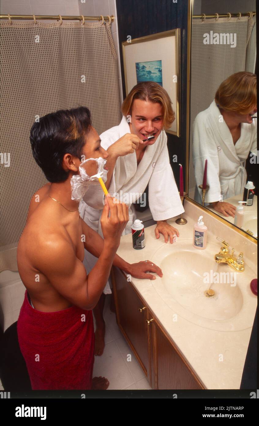 Zwei junge schwule Männer zusammen im Badezimmer Zähneputzen und Rasieren Stockfoto