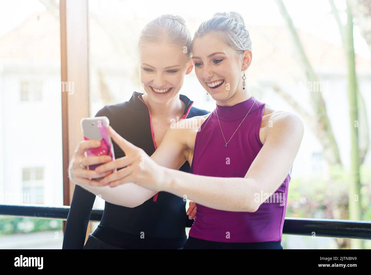 Diese gehen online. Zwei sportliche junge Frauen machen nach dem Training ein Selfie. Stockfoto