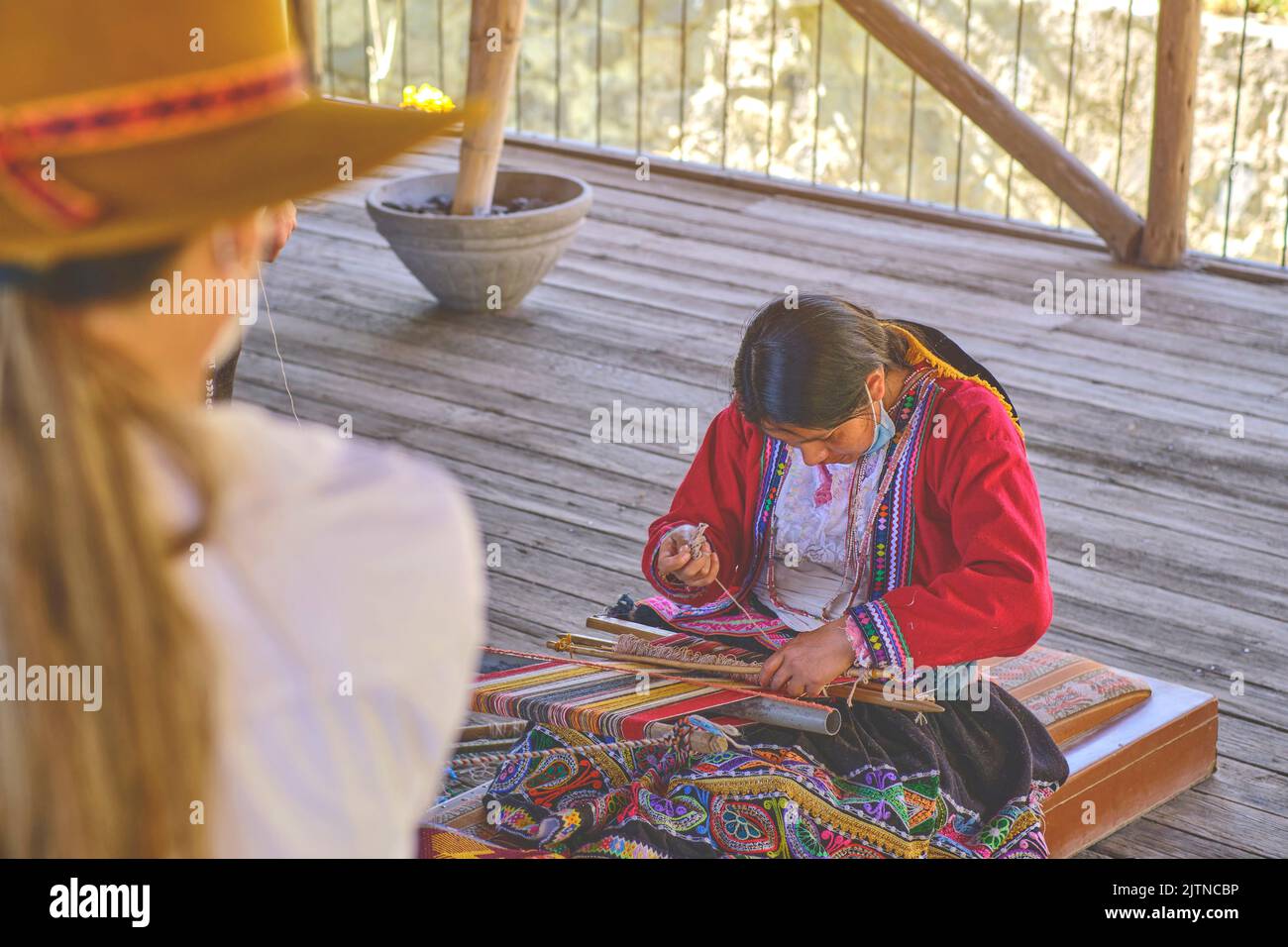 Indigene Frau zeigt traditionelle Webtechnik und Textilherstellung in den Anden in Südamerika in Peru, selektiver Fokus. Stockfoto