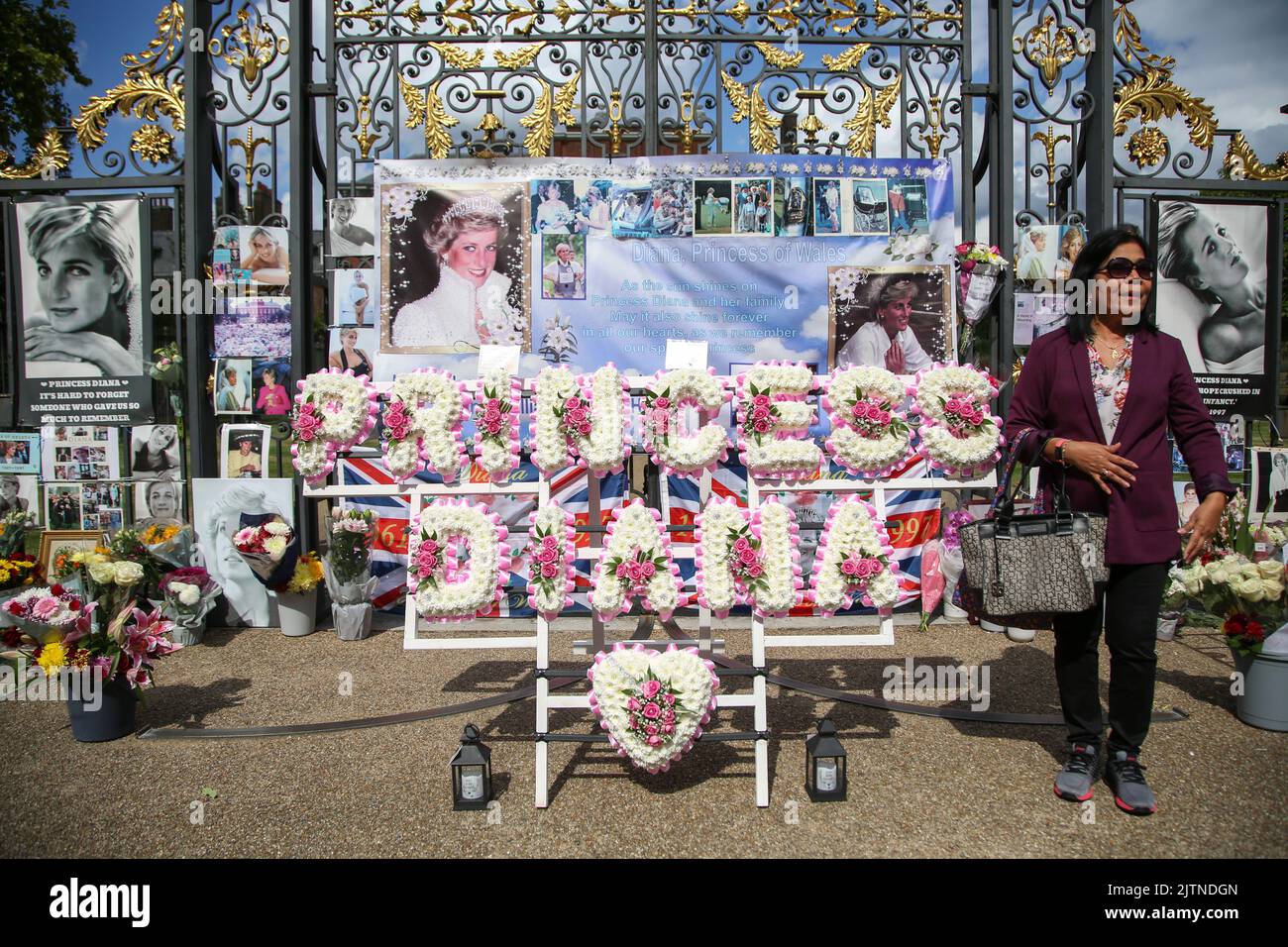 London, Großbritannien. 31. August 2022. Ein Wohlhabender posiert vor den Erinnerungsstücken vor dem Kensington Palace in London zum 25.. Todestag von Diana, Prinzessin von Wales, die in den frühen Morgenstunden des 31. August 1997 nach einem tödlichen Autounfall im Tunnel Pont de l'Alma im Krankenhaus Pitie-Salpetriere in Paris starb. Kredit: SOPA Images Limited/Alamy Live Nachrichten Stockfoto