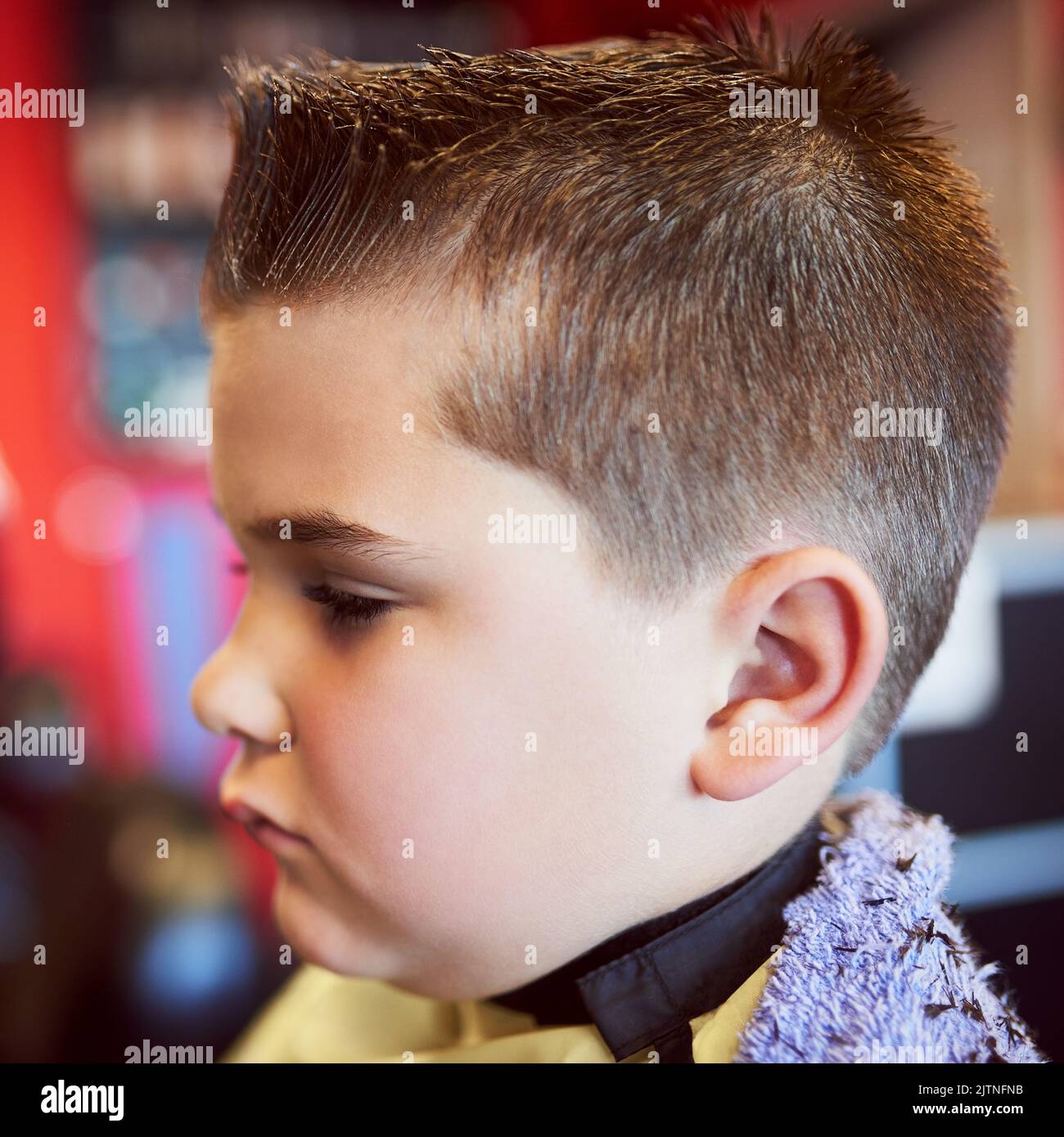 Dieses wird etwas nehmen, das sich an...Nahaufnahme eines kleinen Jungen, der einen Haarschnitt an einem Friseur erhält. Stockfoto