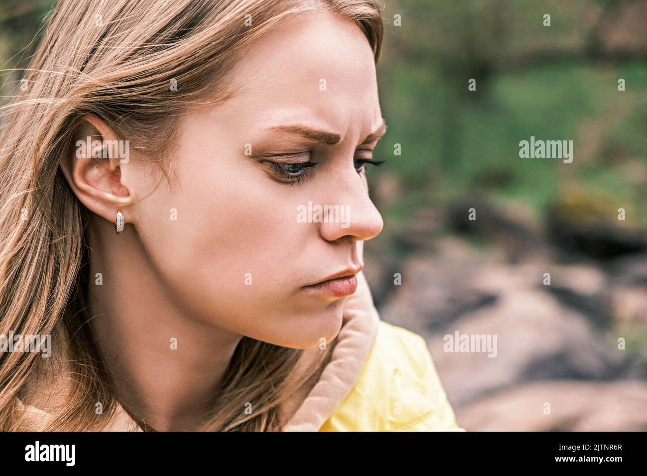 Seitenansicht Porträt einer jungen, ernsthaft verärgerten Frau, die ihre Zähne mit einem angespannten Kiefer zusammenklemmte. Stockfoto