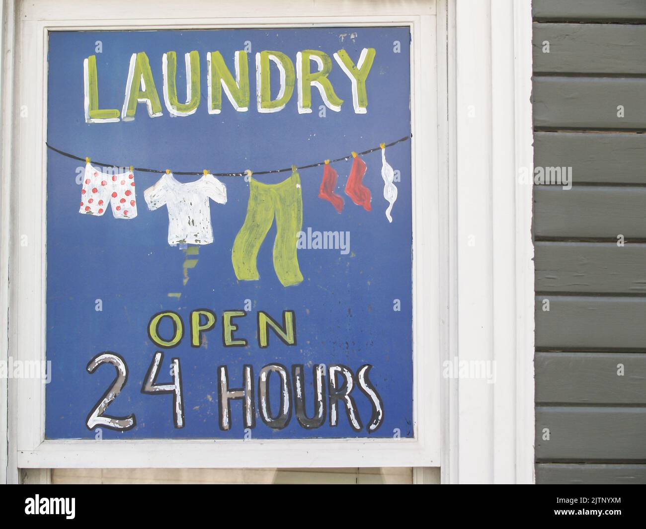 Ketchikan, Alaska USA - 25. JULI; 2008 handbemaltes Schild, das Hauswäsche auf blauem Hintergrund aus der Nähe des Fensters anwirbt Stockfoto