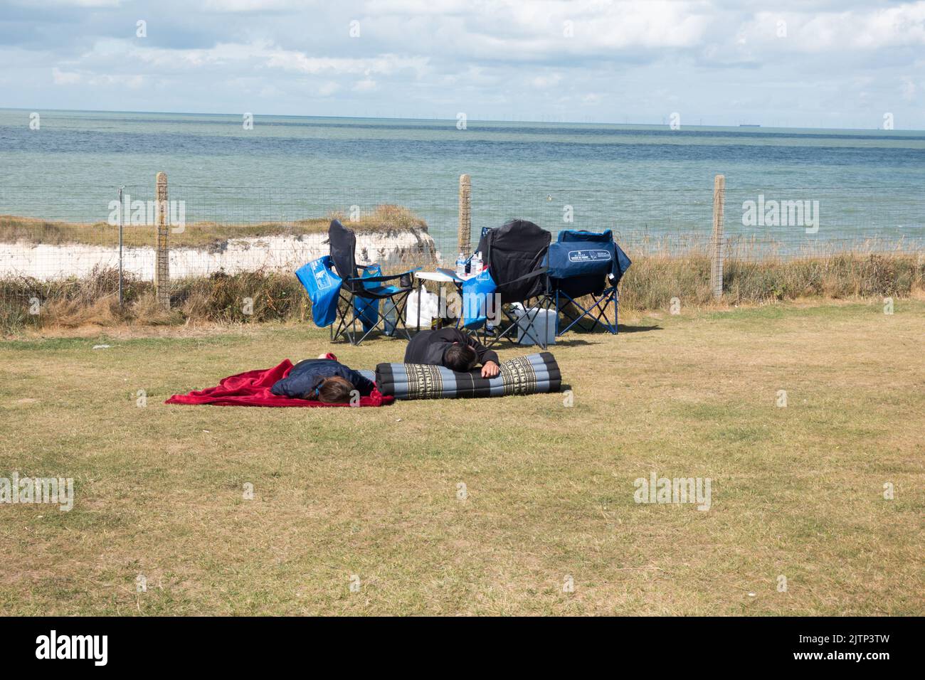 Familie mit Campingstuhl und Matten, die sich an den Klippen der Botany Bay entspannen Stockfoto