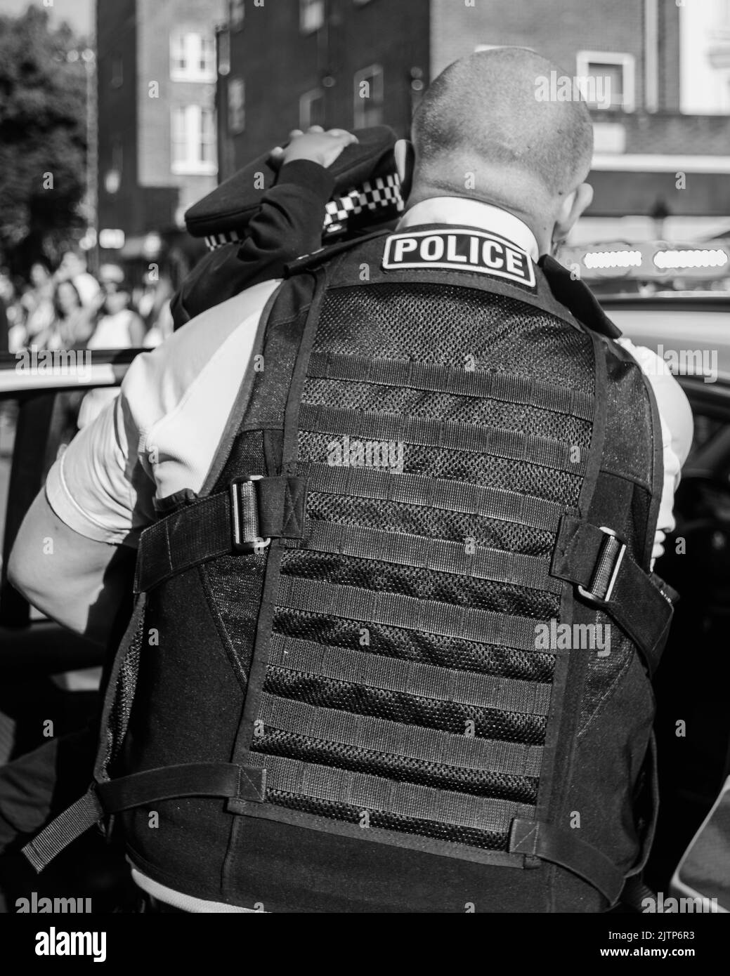 Ein Polizeibeamter lenkt und tröstet ein kleines Kind, das seine Eltern beim Notting Hill Carnival verloren hat. Stockfoto