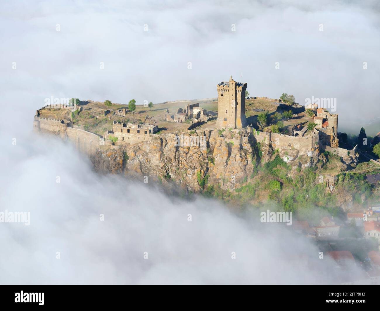 LUFTAUFNAHME. Festung von Polignac, auf einer basaltischen mesa mit dem tief liegenden Morgennebel. Polignac, Haute-Loire, Auvergne-Rhône-Alpes, Frankreich. Stockfoto