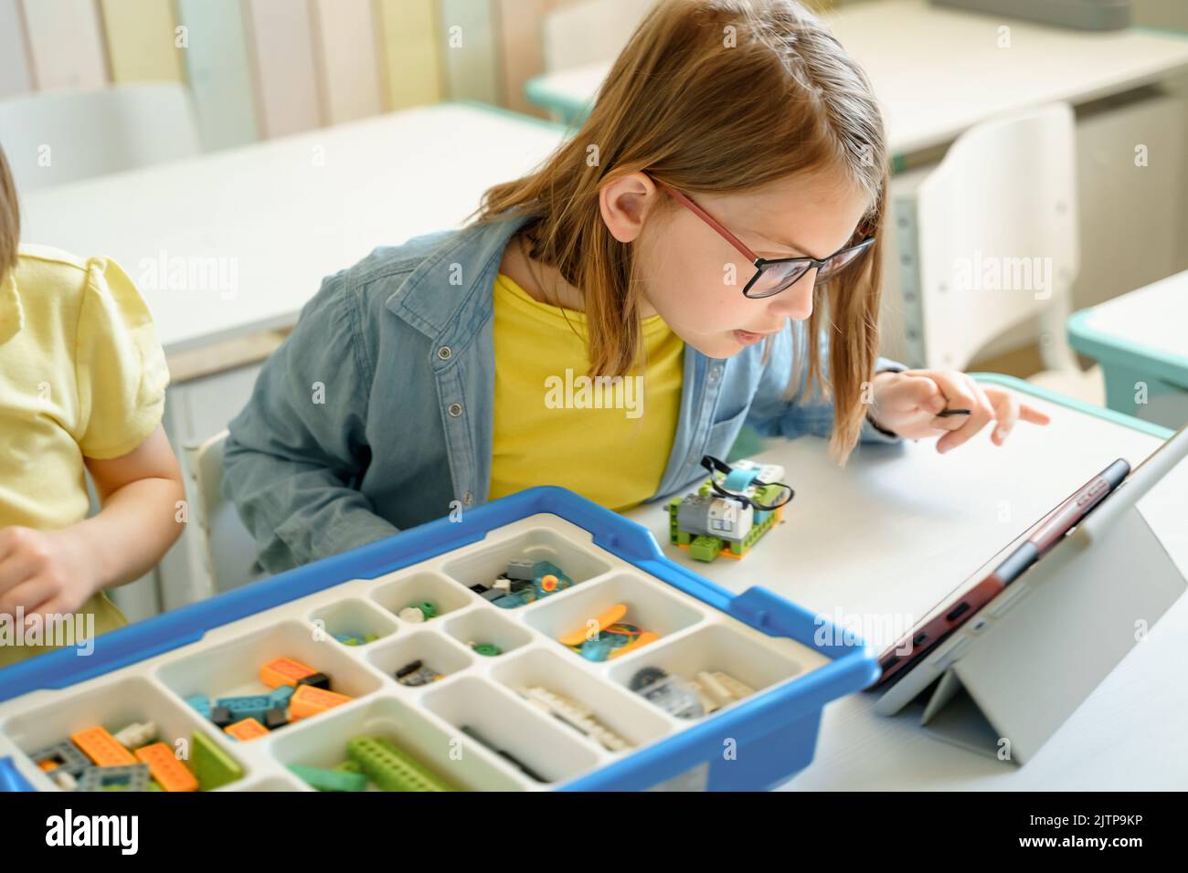 Programmierarbeit, Robotik in der Grundschule lernen. Kinder Studenten Montage, Start, Codierung des Roboters. Konstruktorteile nach Anweisungen in ta Stockfoto