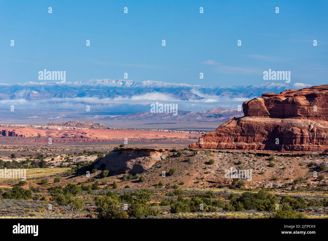 Der Rand von Big Mesa im Vordergrund mit den schneebedeckten Book Cliffs im Hintergrund in der Nähe von Moab, Utah. Stockfoto