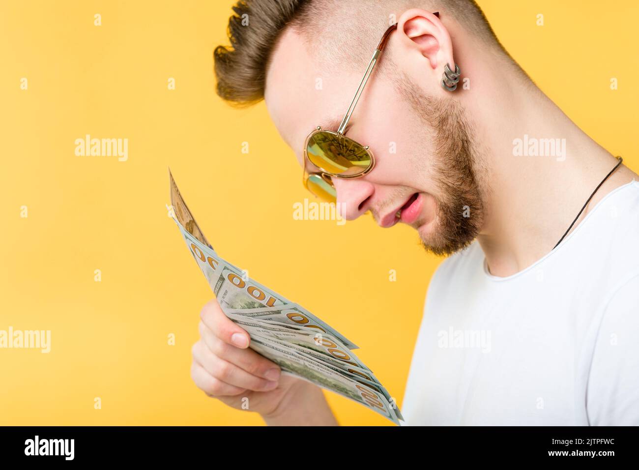Erfolgreiche Millennial verwirrt Kerl Porträt Geld Stockfoto