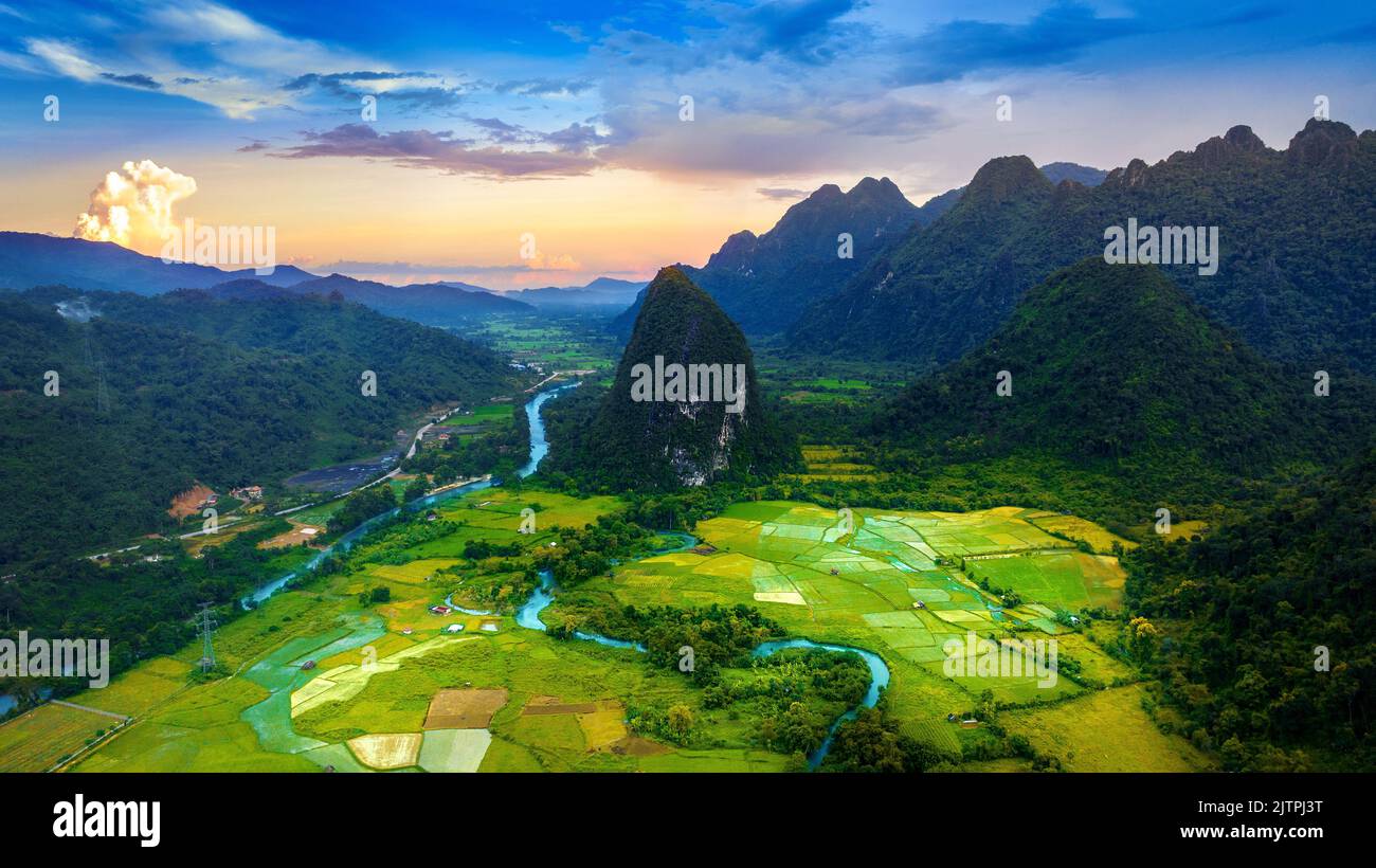 Luftaufnahme von Kalksteinbergen und Reisfeld bei Sonnenuntergang in Vang vieng, Laos. Stockfoto