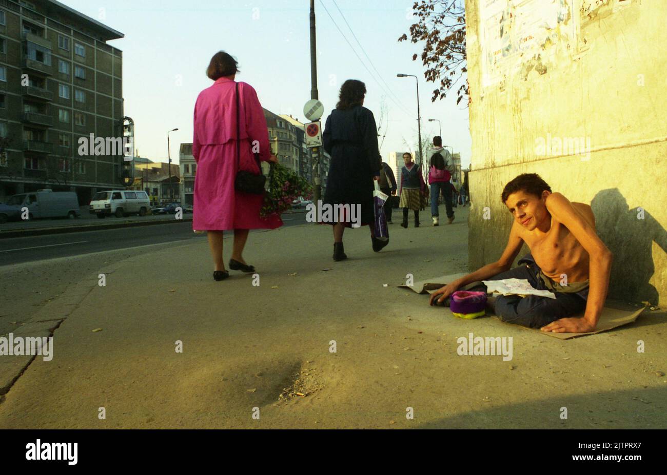 Bukarest, Rumänien, 1992. Junger Mann mit schwerer Behinderung bettelt auf der Straße. Stockfoto