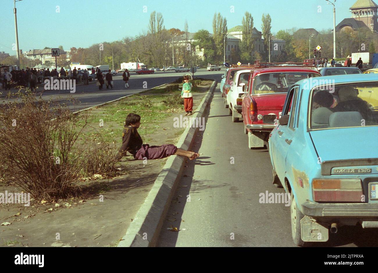 Bukarest, Rumänien, 1990. Junger Mann mit schwerer Behinderung bettelt auf der Straße. Stockfoto