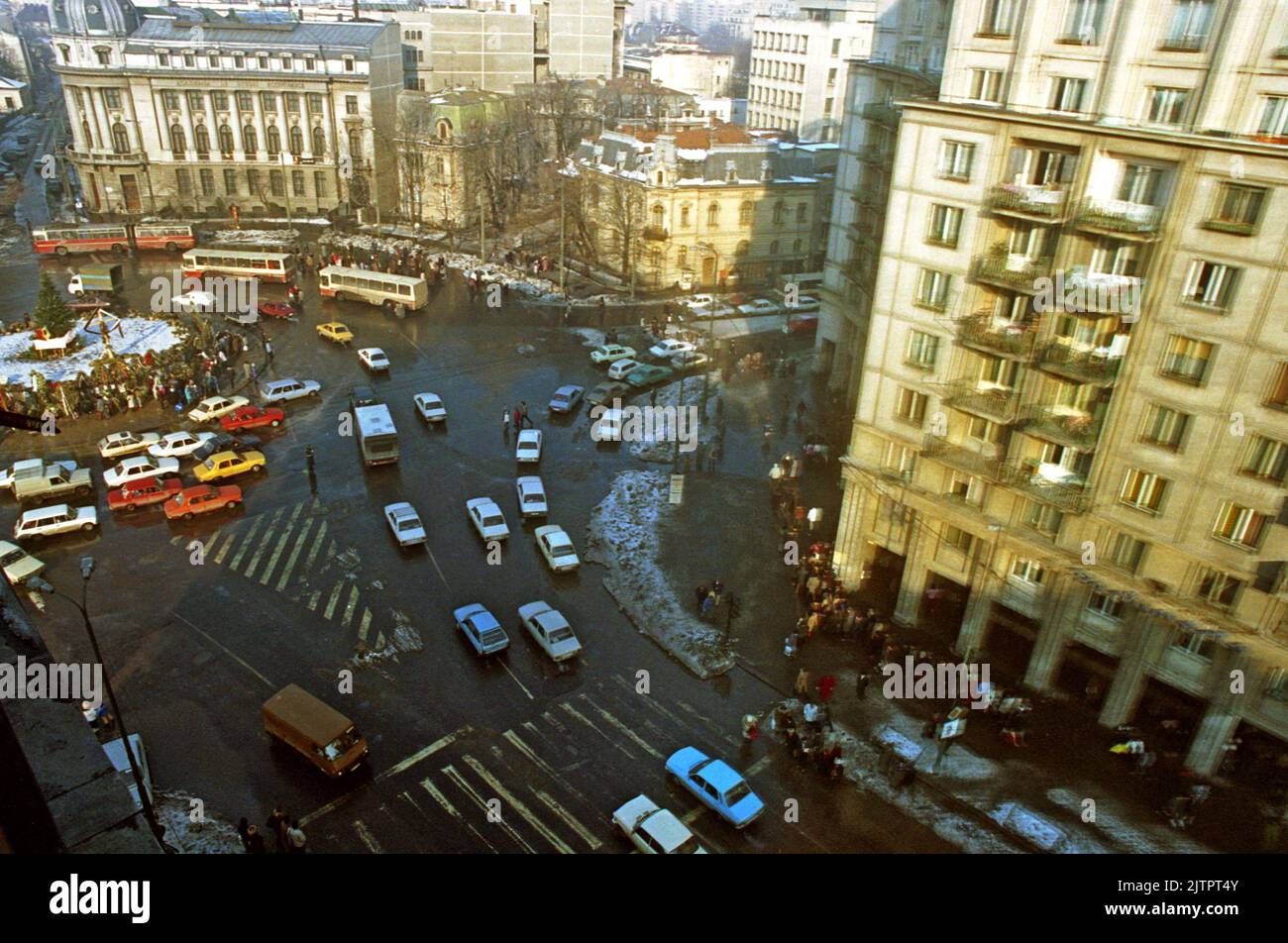 Bukarest, Rumänien, Januar 1990. Blick auf den Romana-Platz, einer der Schlüsselpunkte während der antikommunistischen Revolution im Dezember 1989. In den Wochen nach dem Ereignis versammelten sich täglich Menschen, um Blumen an der Gedenkstätte zu legen (links), Kerzen anzuzünden und zu beten. Stockfoto